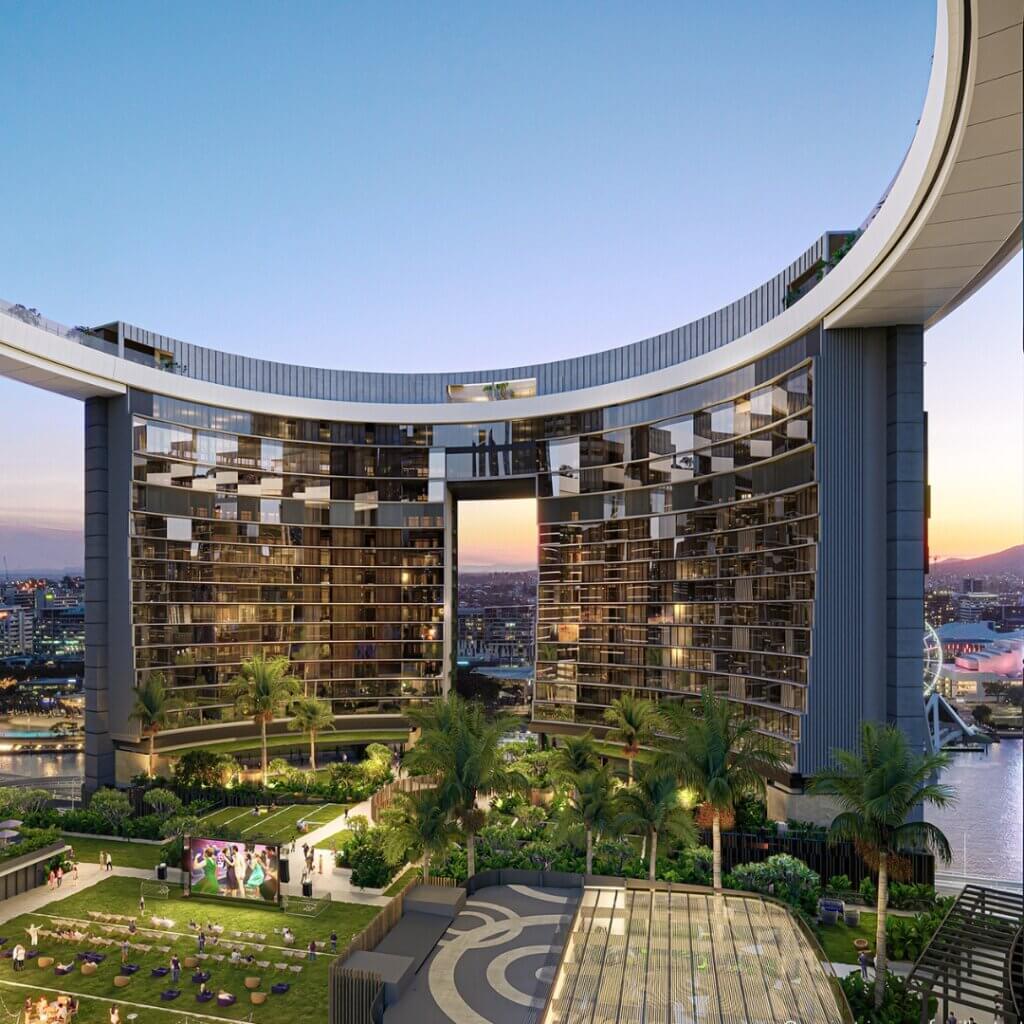 A modern high-rise building with a curved design and reflective glass exterior stands against a twilight sky. As part of the Melt Festival 2024 spectacle, the rooftop features a lush garden with trees, lounge chairs, and people relaxing. The cityscape provides a stunning backdrop.