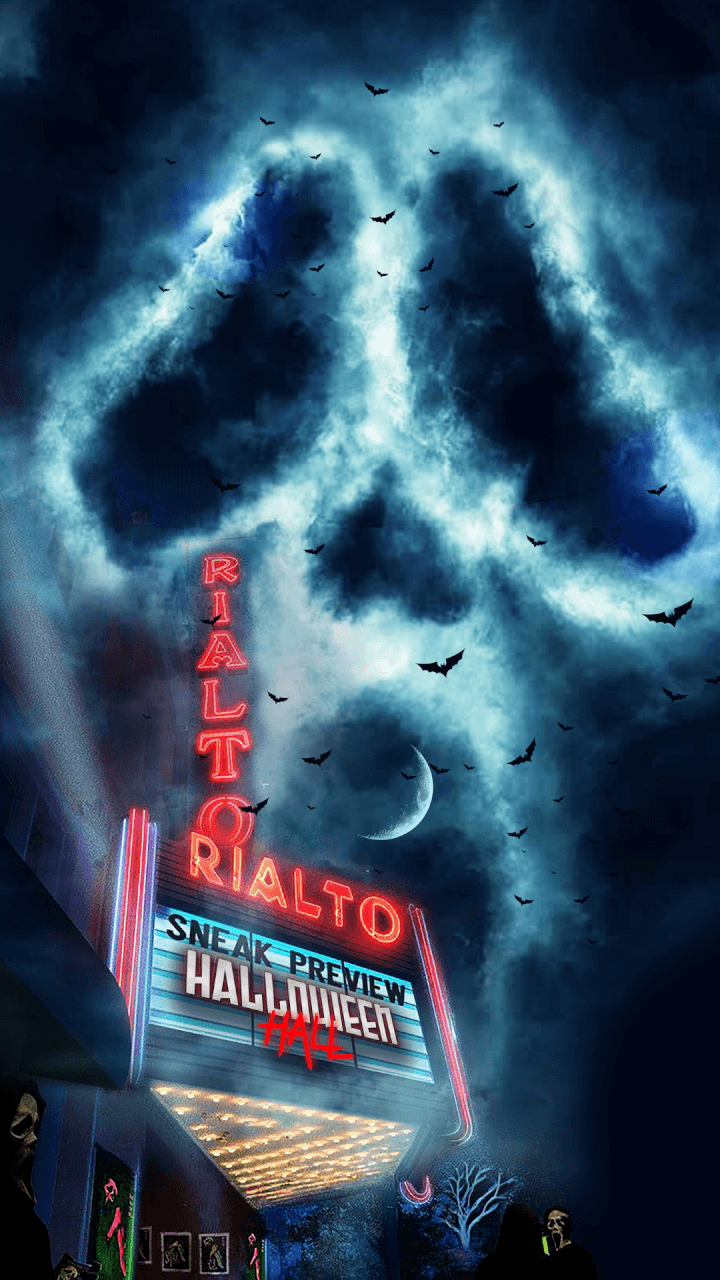 A spooky movie theater at night with a glowing marquee showing SNEAK PREVIEW HALLOWEEN, bats flying, and clouds forming a large skull shape in the sky.