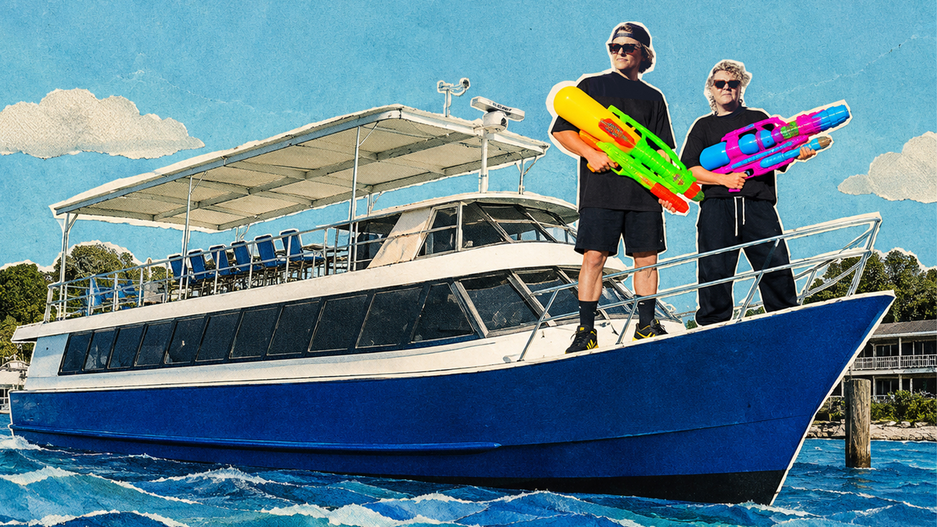 Two people in black outfits stand on the bow of a blue and white boat, each holding large colorful water guns, with water and a shoreline visible in the background.
