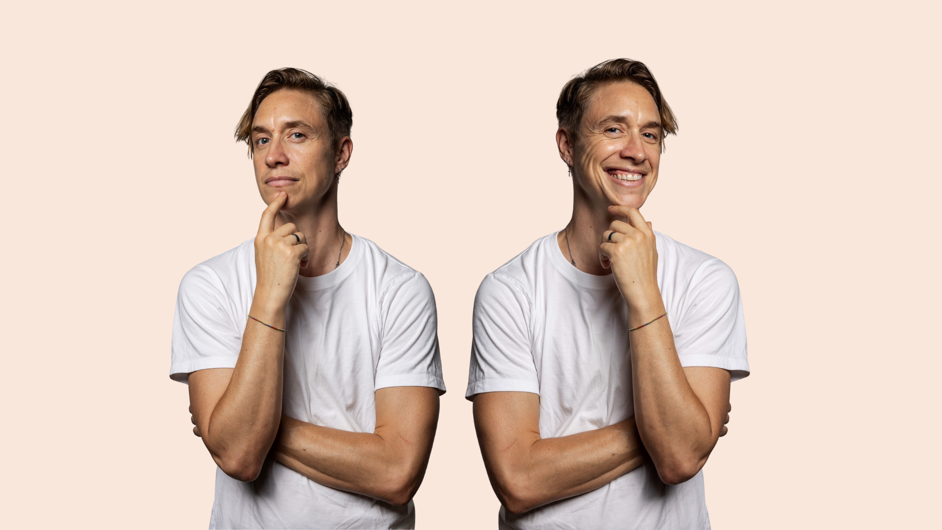 Two men in white t-shirts stand side by side against a light background, each with one hand on their chin. One man looks neutral while the other is smiling broadly.