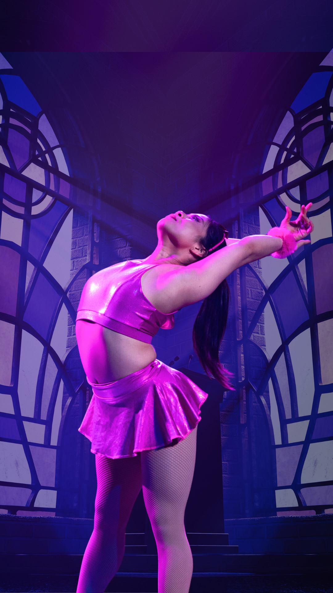 A dancer in a shiny pink outfit strikes a dramatic pose with arms outstretched and head tilted back, standing in front of large arched windows with purple lighting.